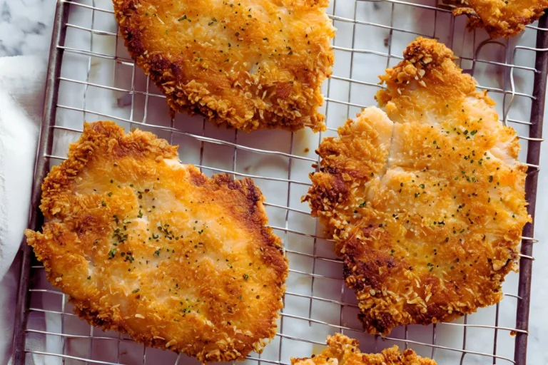 Golden chicken cutlets on a wire rack with crispy breading